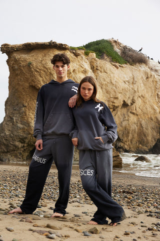 A group of models in coordinated Aries loungewear, featuring a gradient ombre dip-dye, adjustable waistbands, and toggle hems, all made from premium materials.