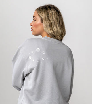 solar system in white on light grey crewneck, located on back of crewneck near shoulder