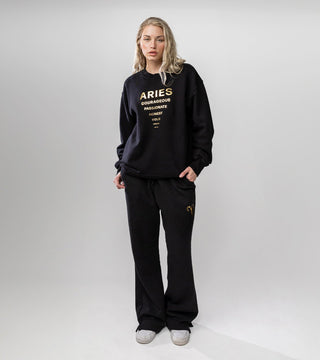 Black crewneck sweatshirt with "Aries" and list of Aries personality traits in metallic gold foil.