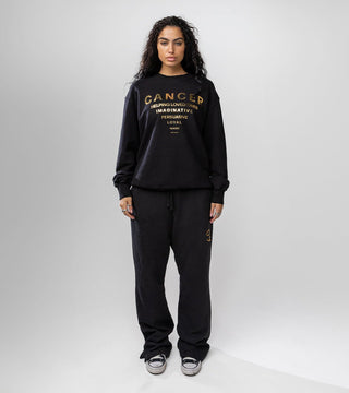 black crewneck with "Cancer" in gold foil and list of Cancer personality traits