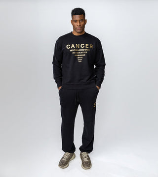 black crewneck with "Cancer" in gold foil and list of personality traits
