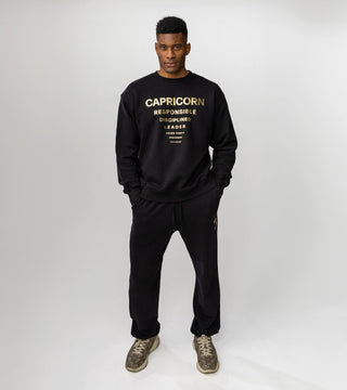 black crewneck with gold reflective foil reading "Capricorn" and Capricorn personality traits